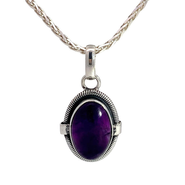 photo of a silver oval amethyst cabochon pendant on a silver chain on a white background