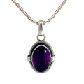 photo of a silver oval amethyst cabochon pendant on a silver chain on a white background