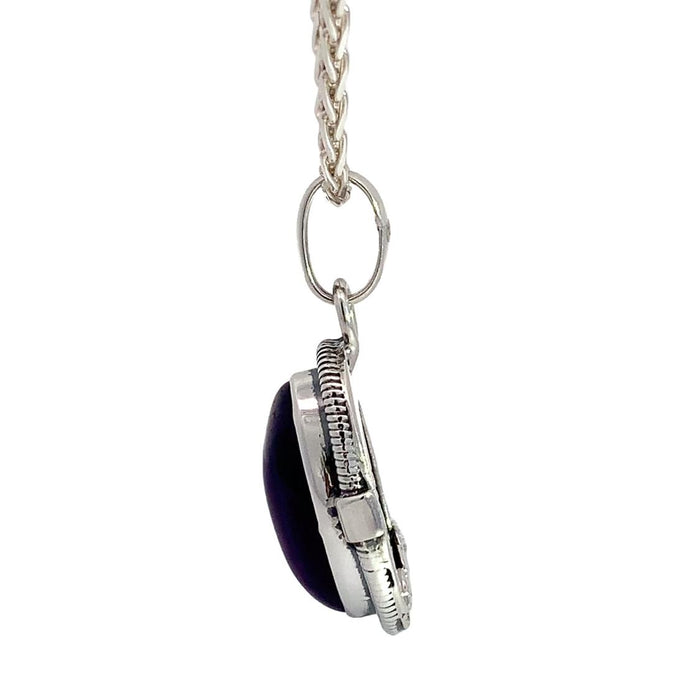 photo of a silver oval amethyst cabochon pendant on a silver chain on a white background side view