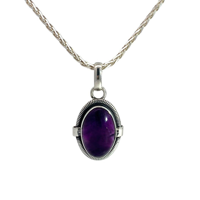photo of a silver oval amethyst cabochon pendant on a silver chain on a white background