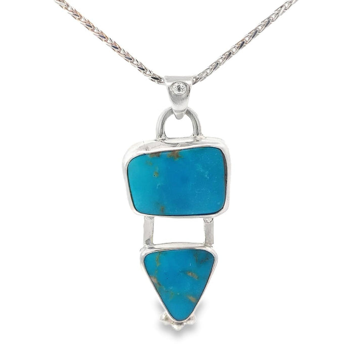 photo of a silver pendant with two bezel set turquoises on a silver chain taken on a white background