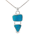 photo of a silver pendant with two bezel set turquoises on a silver chain taken on a white background