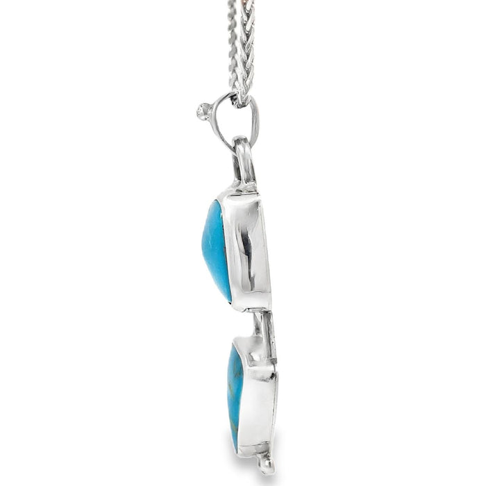 photo of a silver pendant with two bezel set turquoises on a silver chain taken on a white background side view