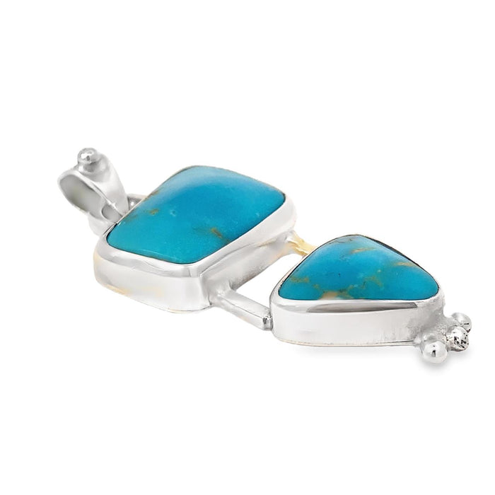 photo of a silver pendant with two bezel set turquoises  taken on a white background
