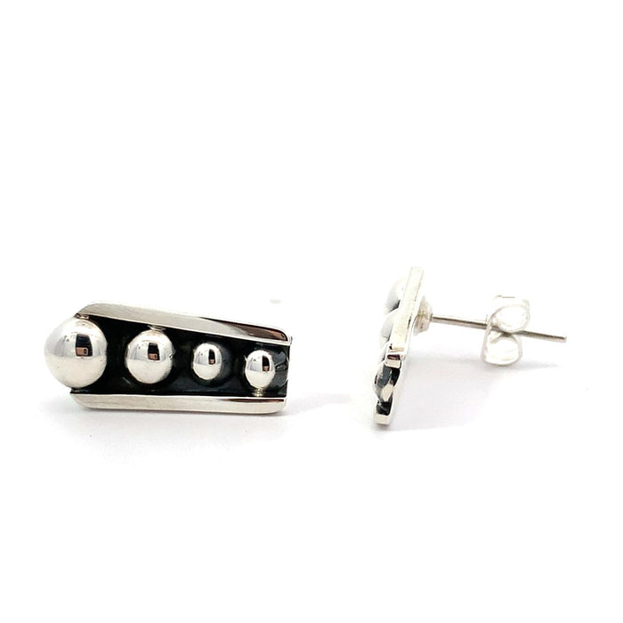 photo of silver tapering earrings with raised dots and a black oxidation on a white background duo