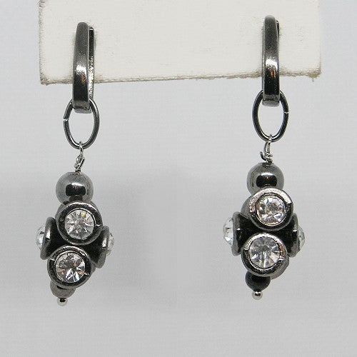 Pair of black metal earrings with clear gemstones on a white background