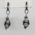 Pair of black metal earrings with clear gemstones on a white background