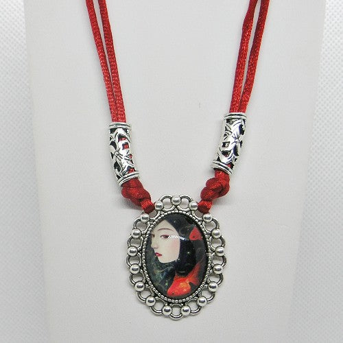 Necklace with a pendant featuring a portrait on a red cord against a white background