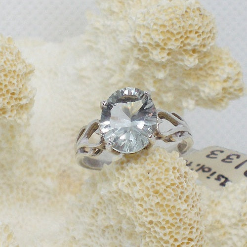 Silver ring with a large diamond on a textured beige surface