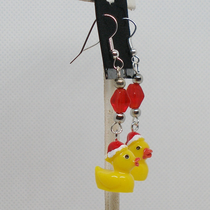 Christmas-themed duck earrings with red beads on a white background