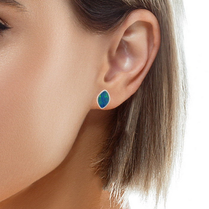 photo of a brunette model wearing a single silver marquise shaped stud earring with blue-green hues on a white background