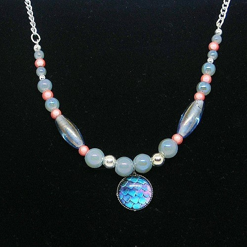 Necklace with blue and pink beads and a colorful pendant on a black background