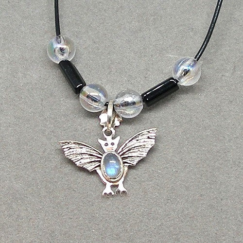 Necklace with stone bat pendant and beaded chain on a gray background