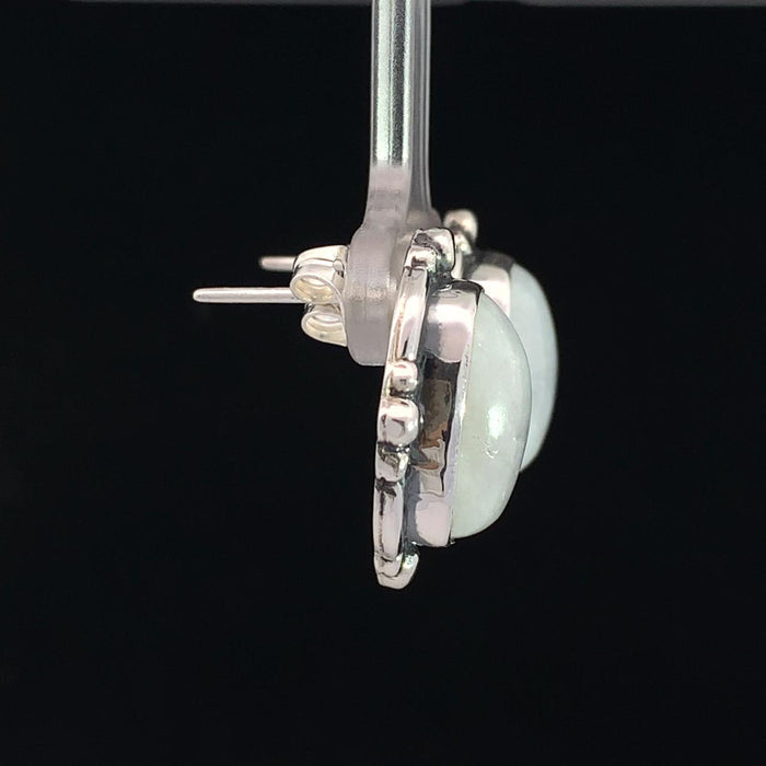 photo of a pair of silver white moonstone earrings on a black background side view