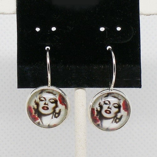 Earrings with circular designs of a famous actress on a black card.