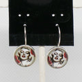 Earrings with circular designs of a famous actress on a black card.
