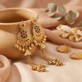 Elegant, festive, and full of graceful detail, the Nayra Gem Jhumka blends traditional charm with a bright jewel-inspired finish. Featuring soft turquoise gem-style accents, intricate golden-tone metalwork, delicate hanging beads, and long chain tassels, these earrings create a beautiful statement that feels rich, feminine, and perfect for special occasions.