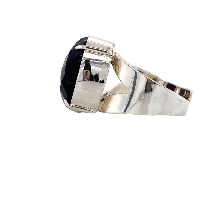 photo of a silver oval faceted amethyst ring on a white background side view
