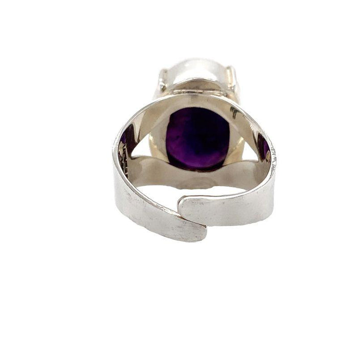 photo of a silver oval faceted amethyst ring on a white background rear view