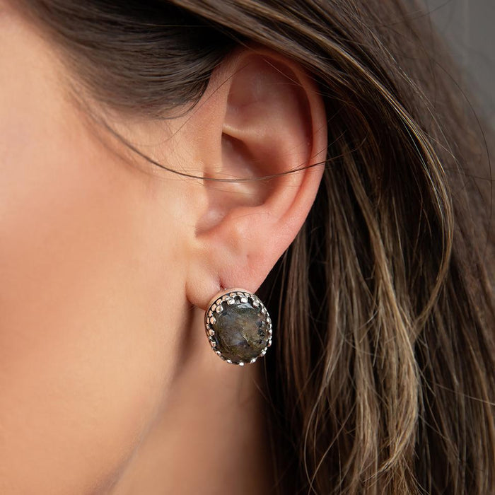 Photo of a brunette model wearing an oval silver labradorite earring