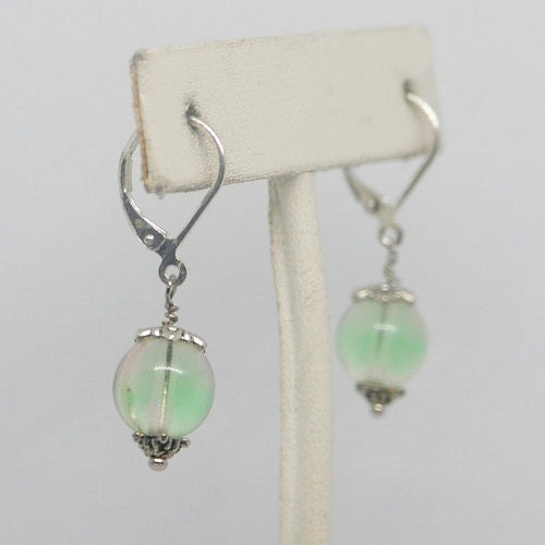 Pair of earrings with green beads on a white background
