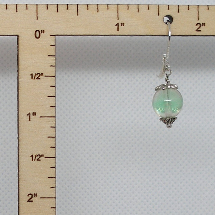 Green beaded earring with silver hook on a ruler for scale