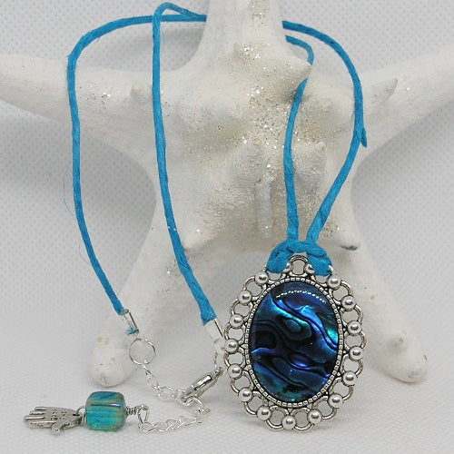 Necklace with blue pendant and blue cord on a white background