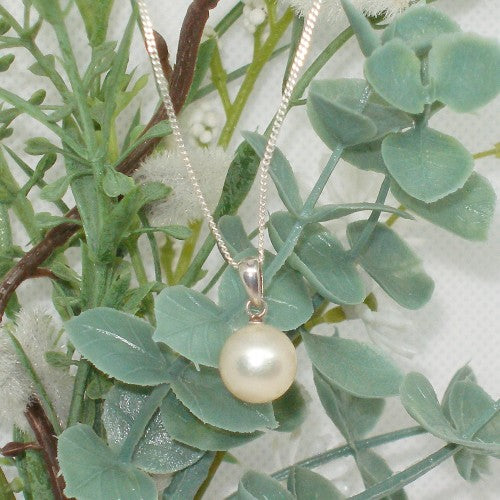 Pearl necklace on a green leafy background
