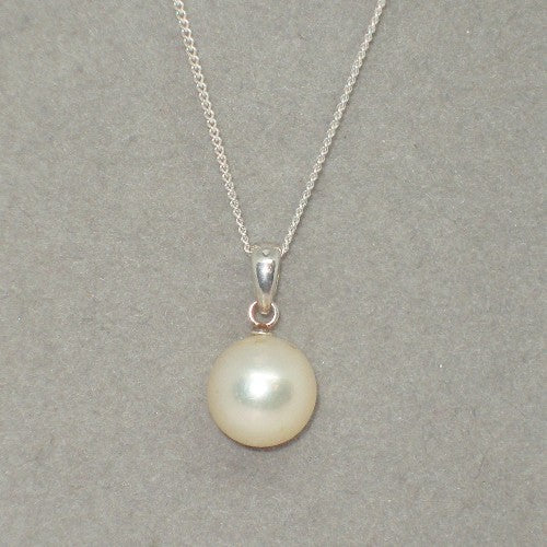 Pearl pendant on a silver chain against a gray background