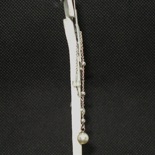 Pearl threader earring with chain on a textured black background