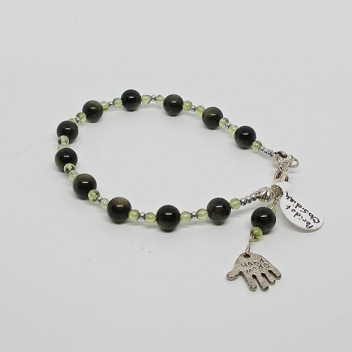 Bracelet with black and green beads on a white background