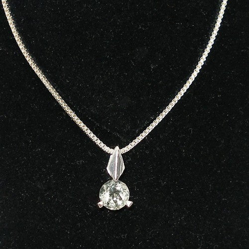 Necklace with a pendant featuring a green gemstone on a black background