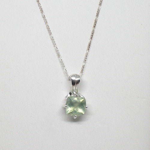 Silver necklace with a green gemstone pendant on a white background