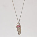 Silver pendant with a pink gemstone on a light gray background