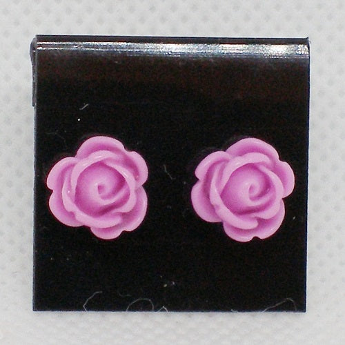 Pair of purple rose-shaped earrings on a black card with a gray background