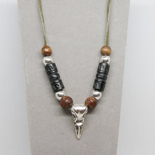 Necklace with beads and a silver raven skull pendant on a gray background