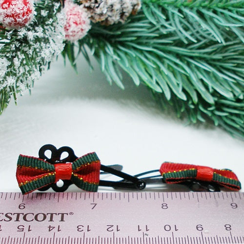 Red and green bow hair clips on a ruler with Christmas decorations in the background