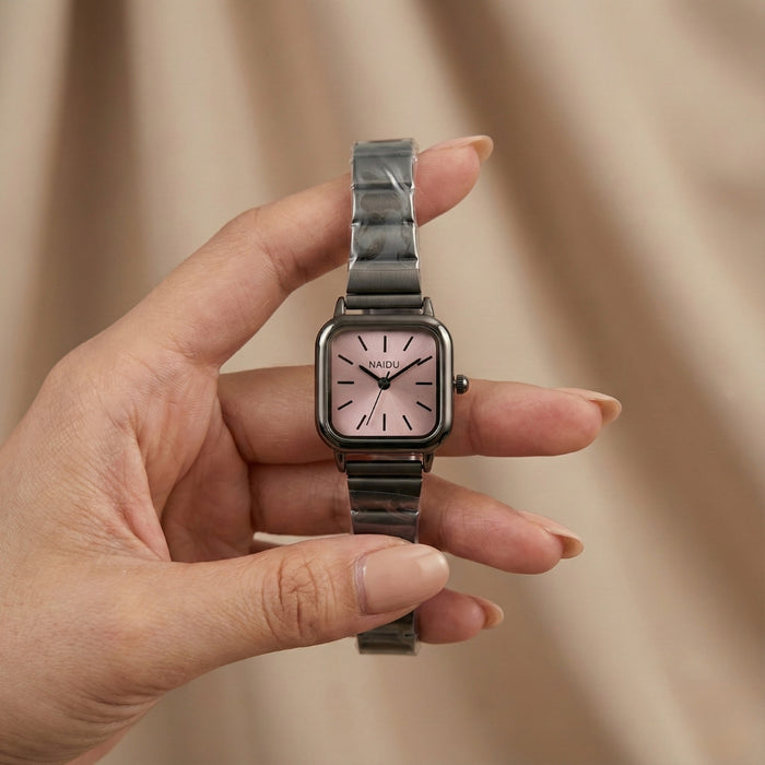 The Retro&nbsp;Noir Watch blends modern minimalism with everyday sophistication. Featuring a compact square dial with a subtle sunray texture, clean pointer markers, and a slim profile, it’s designed to sit gracefully on the wrist. Finished with a stainless-steel strap and refined detailing, this piece is made for effortless daily styling.
