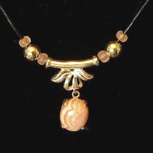 Necklace with silver and pink beads on a black background