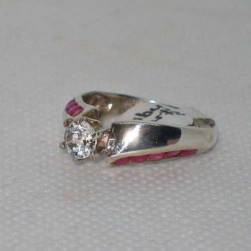 Silver ring with a quartz and ruby stones on a gray background