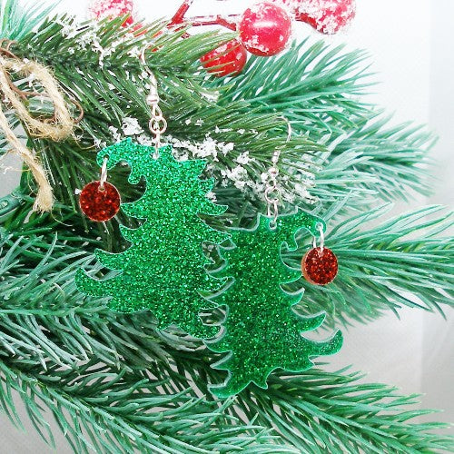 Green glittery Christmas tree earrings with red ornament on a branch.