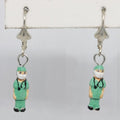 Earrings with doctor figurines wearing green scrubs on a white background