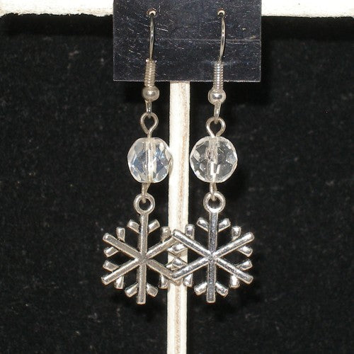 Silver snowflake earrings with clear beads on a black background