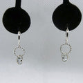 Silver earrings with circular designs and pale blue stones on a gray background