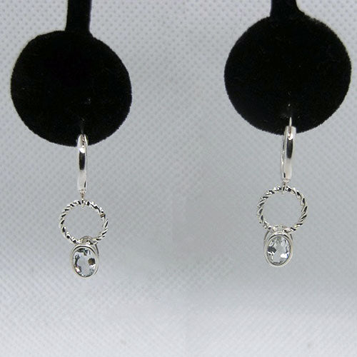 Silver earrings with circular designs and pale blue stones on a gray background