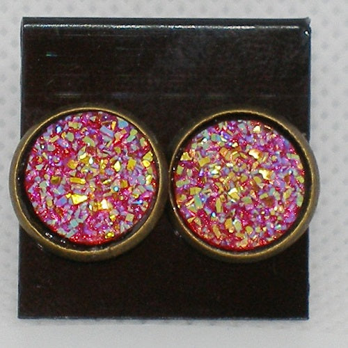 Pair of round earrings with red and gold glittery design on a black card.