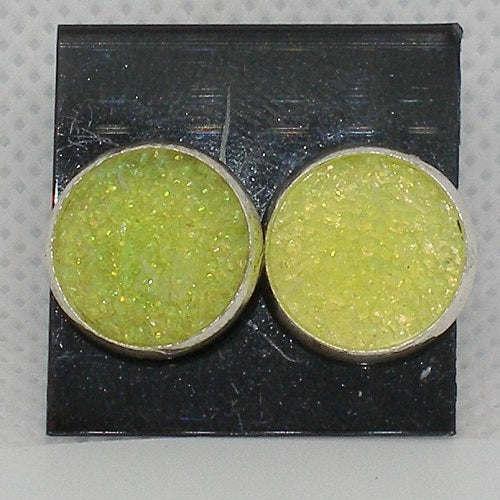 Round yellow earrings with silver rims on a black card