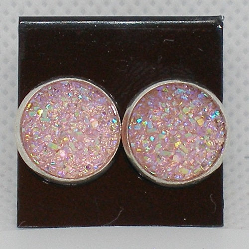 Pair of round pink glittery earrings on a black card.