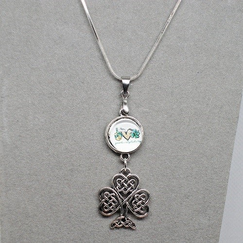 Silver necklace with a shamrock pendant on a gray background