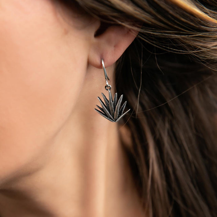 photo of a brunette model wearing a silver agave-themed drop silver earrings